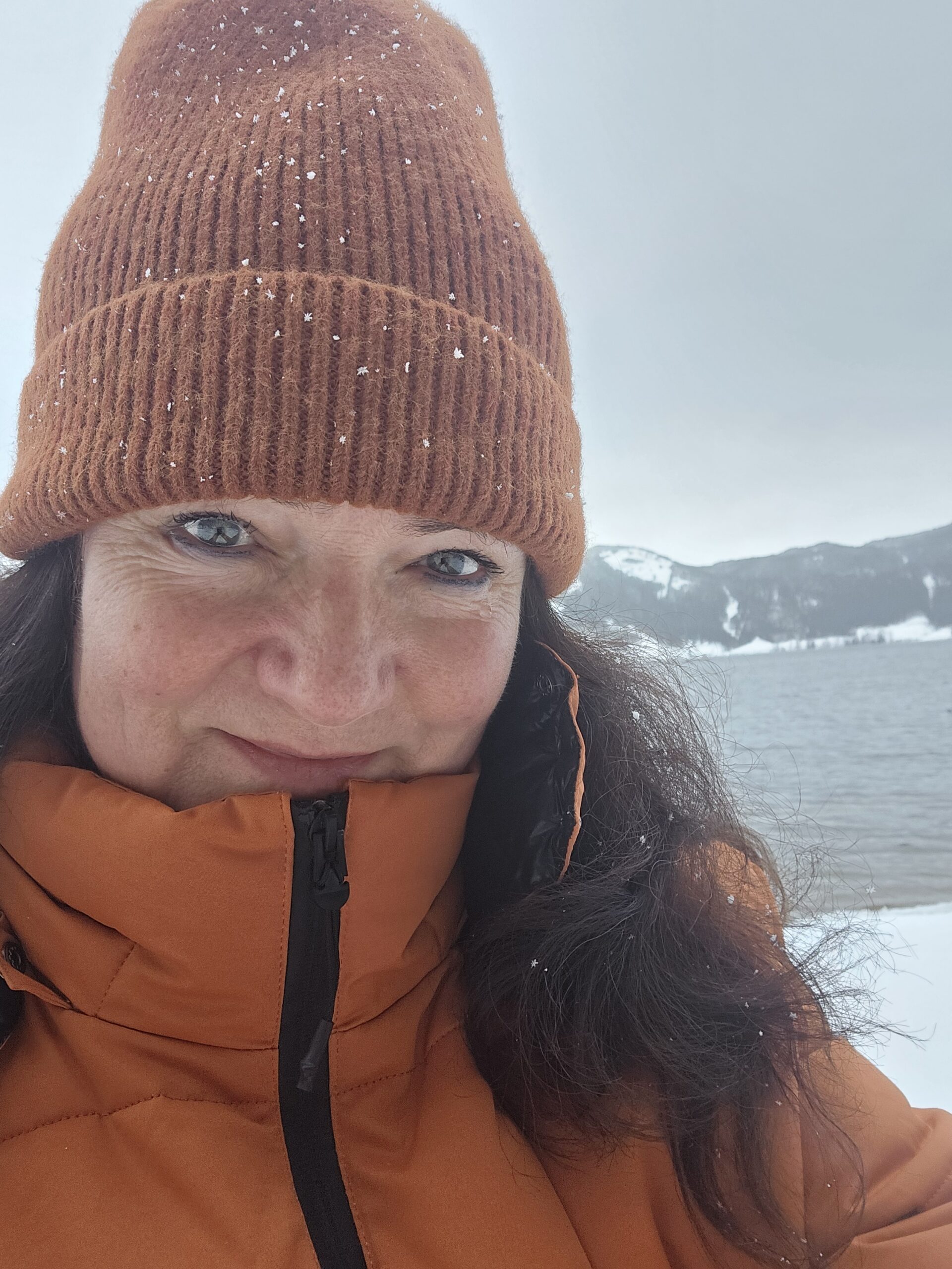 Silke mit Mütze an einem See im Winter